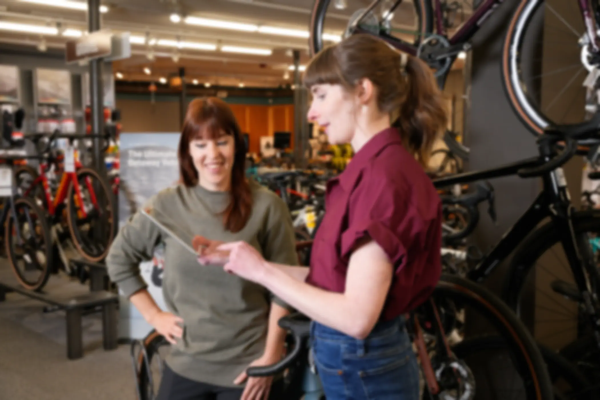 Two people browsing a Workstand website in a bike shop